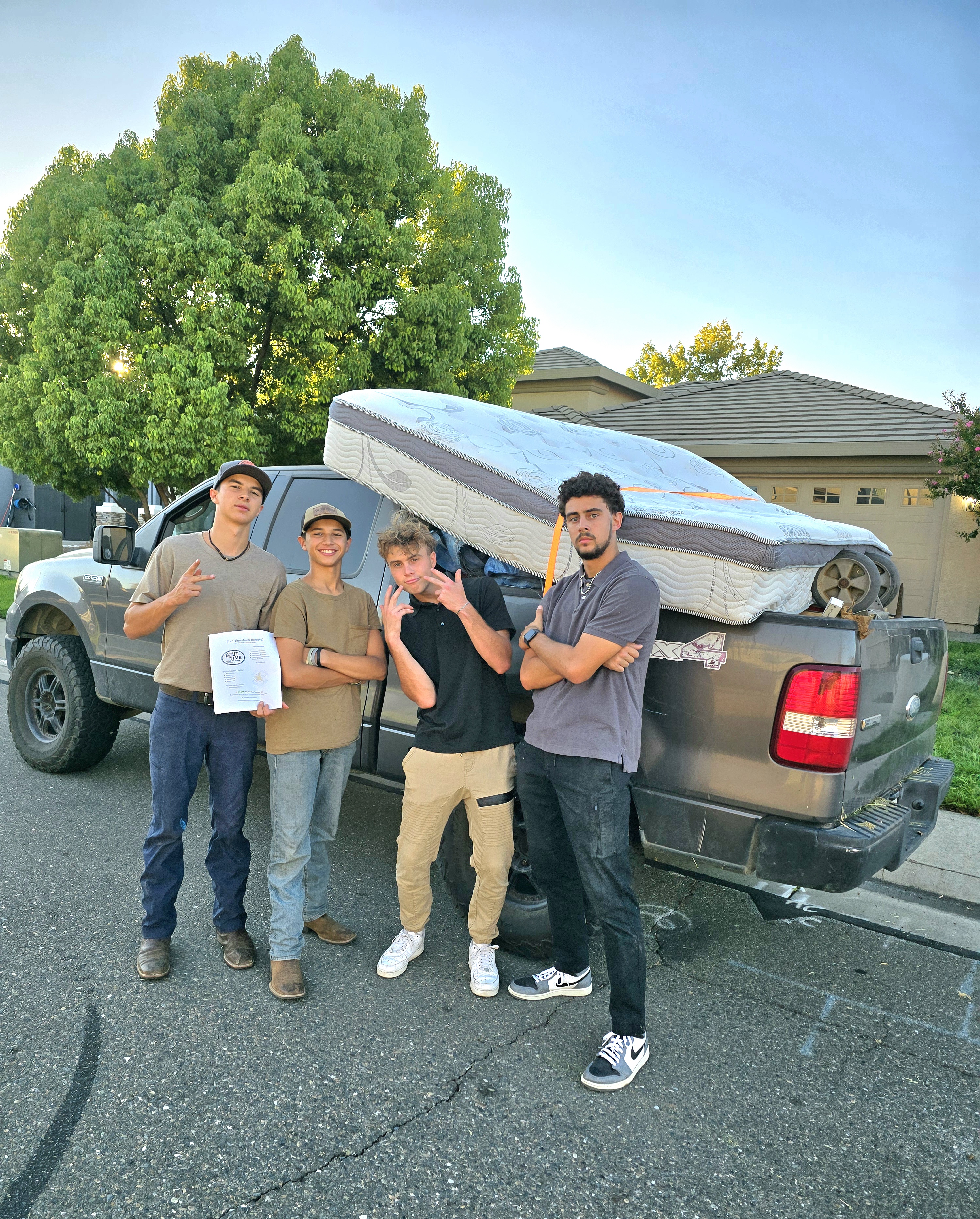 Bout Time Junk Removal crew providing fast, friendly junk removal service in Sacramento & San Joaquin counties, hauling furniture and debris into a clean company truck.