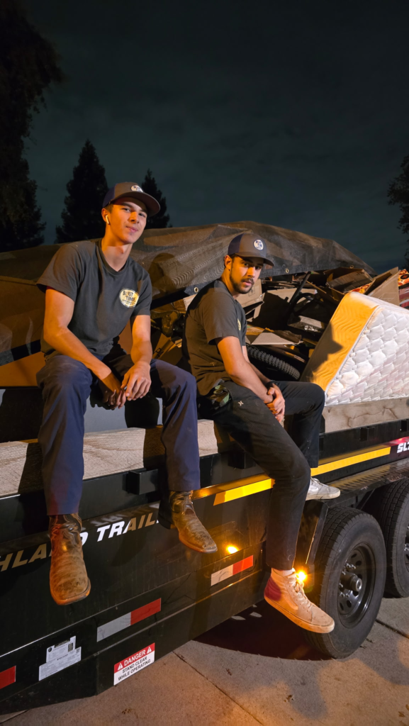 Bout Time Junk Removal crew sitting on loaded trailer after Sacramento junk removal job